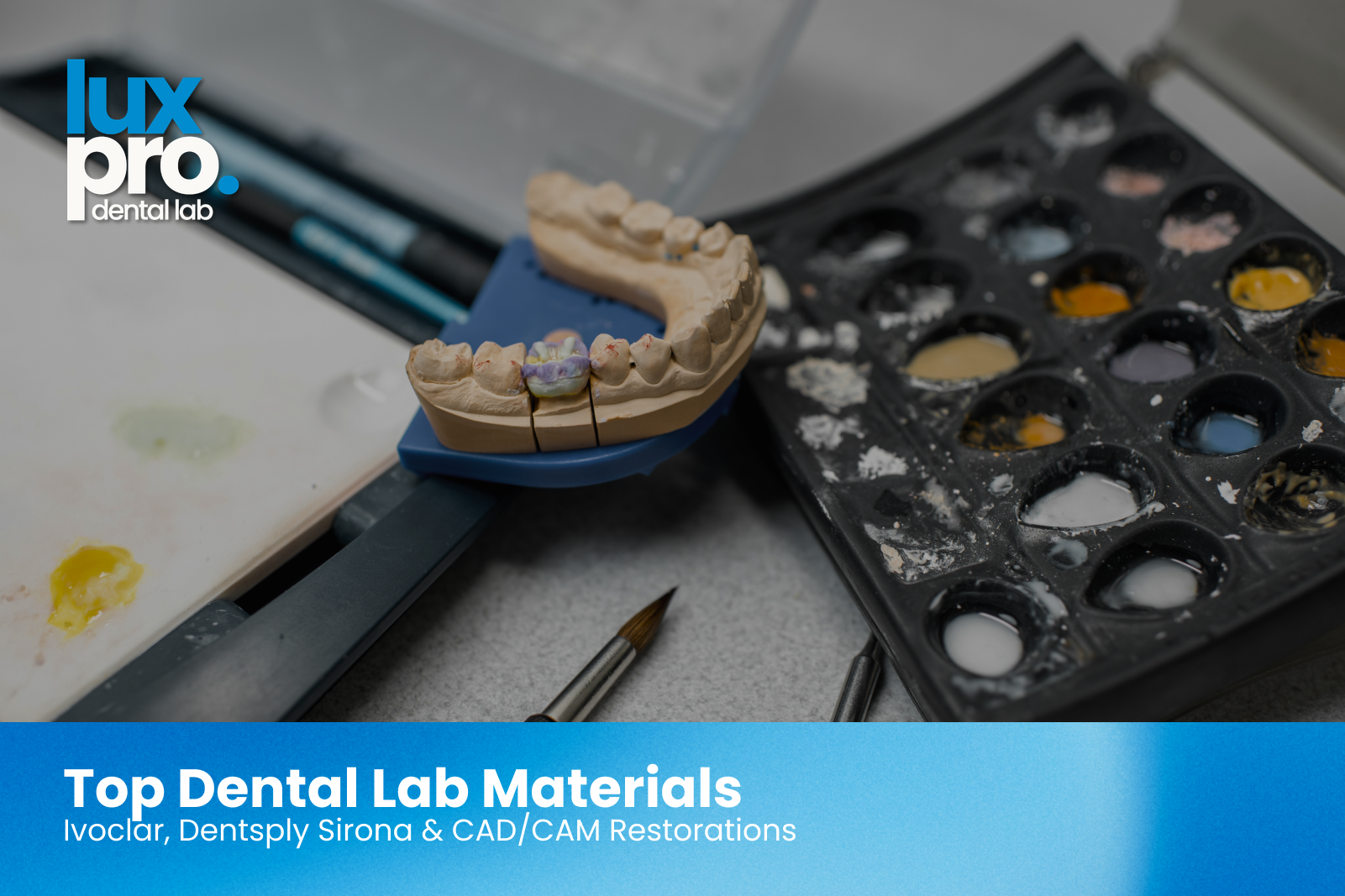 Dental laboratory materials including a crown restoration model, shade guide, and ceramic samples on a professional workstation, showcasing premium dental materials for crowns, implants, and restorative dentistry.